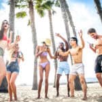 The Cabo Magazine Group of friends having party on the beach, dancing and drinking cocktails